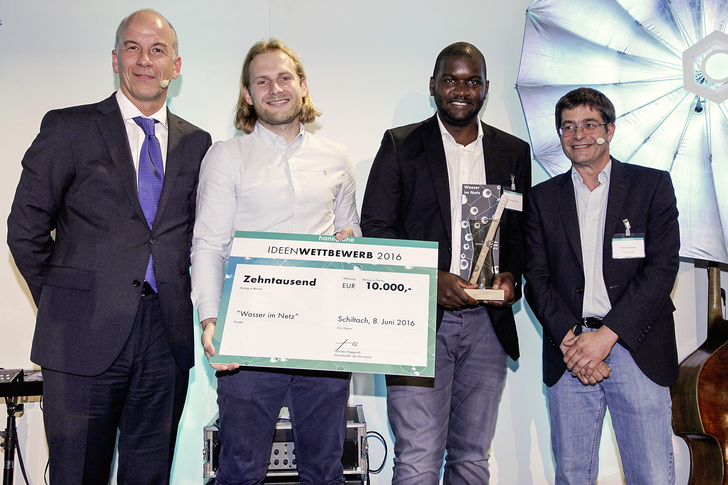 Thorsten Klapproth ­(Vorstandsvorsitzender Hansgrohe SE) mit den ­Gewinnern des ersten Preises Felix Müller und Mulundu ­Sichone und Richard Grohe (v.l.). - © Hansgrohe SE / www.eidens-hall.de

