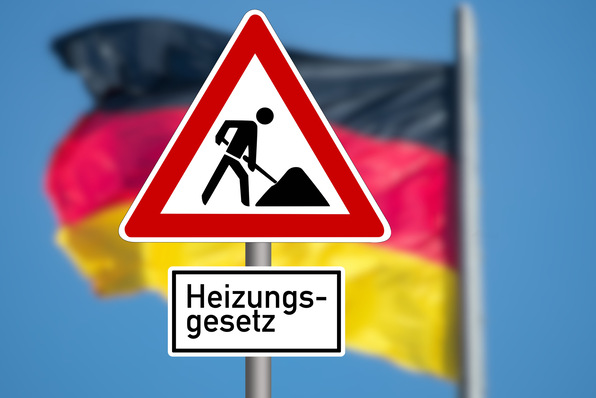 Optimierter Alt-Text: „Warnschild mit der Aufschrift ‚Heizungsgesetz‘ steht vor unscharfem Hintergrund in den Farben der deutschen Flagge und symbolisiert gesetzliche Veränderungen für Heizungsanlagen in Deutschland.“. - © studio v-zwoelf - stock.adobe.com