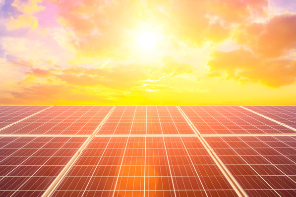 Reihen von Solarmodulen unter einem hellen, sonnigen Himmel mit vereinzelten Wolken bei Sonnenaufgang oder Sonnenuntergang. - © ABCDstock - stock.adobe.com