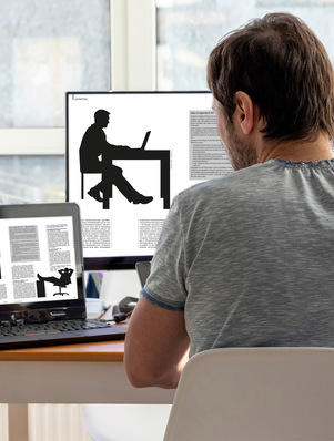 Ein Mann arbeitet an einem Schreibtisch mit einem Laptop, auf dessen Bildschirmen Dokumente und Silhouetten zu sehen sind. - © Bild: MariiaDemchenko - stock.adobe.com