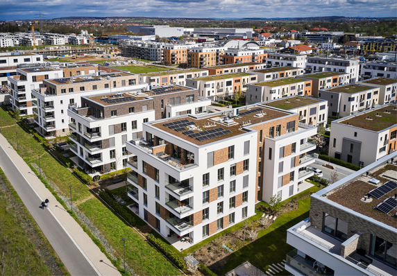Luftaufnahme von modernen Mehrfamilienhäusern mit begrünten Dächern in einem städtischen Wohngebiet. - © Bild: Systemair