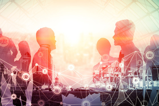 Silhouetten von vernetzten Menschen überlagern sich mit einer Stadtlandschaft und Symbolen für digitale Verbindungen. - © InfiniteFlow - stock.adobe.com