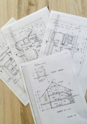 Vier architektonische Grundrisse und Gebäudediagramme, die auf einer Holzunterlage ausgelegt sind. - © Bild: Forum Wohnenergie