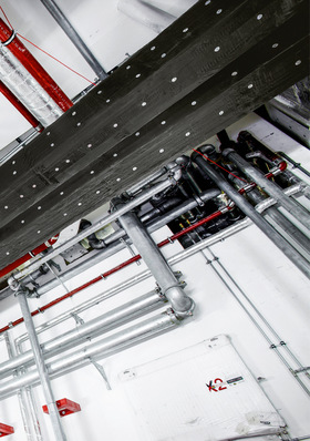 Eine Deckenansicht von freiliegenden Rohren, Kanälen und elektrischen Leitungen in einem Industrie- oder Versorgungsbereich. - © Bild: Deutsche Rockwool