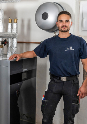 © Bild: Buderus Heizungsinstallateur Paul Hamberger mit der Wärmepumpen-Inneneinheit Logatherm WLW186i-12 TP70 von Buderus.